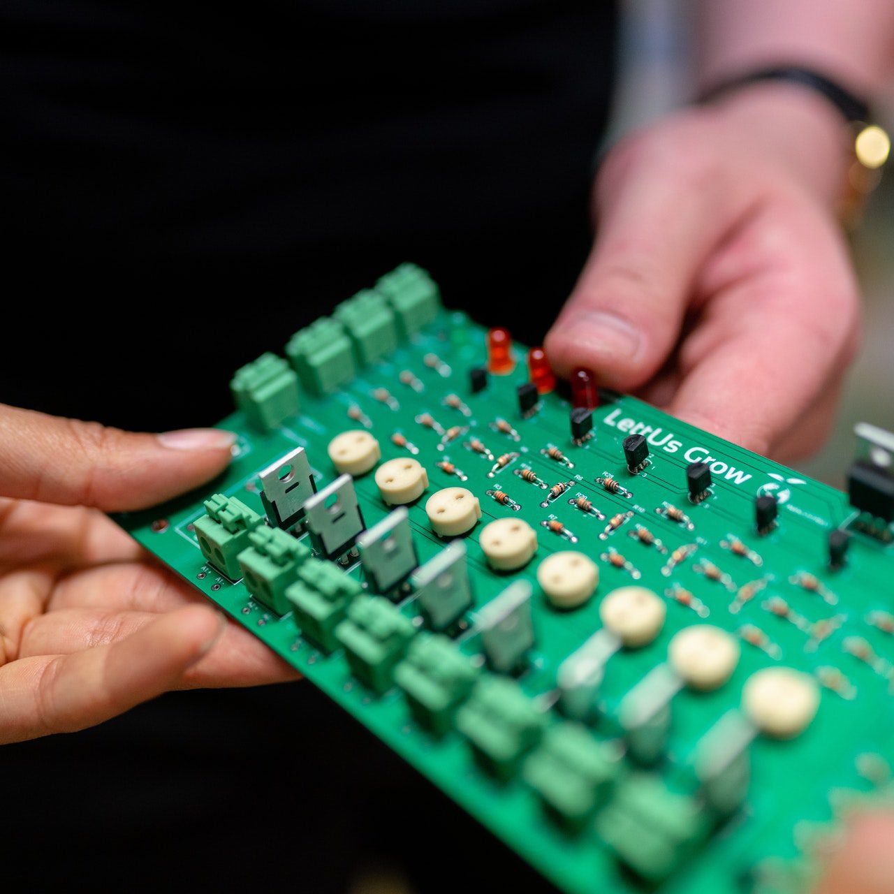 engineers-holding-circuit-board-3912373